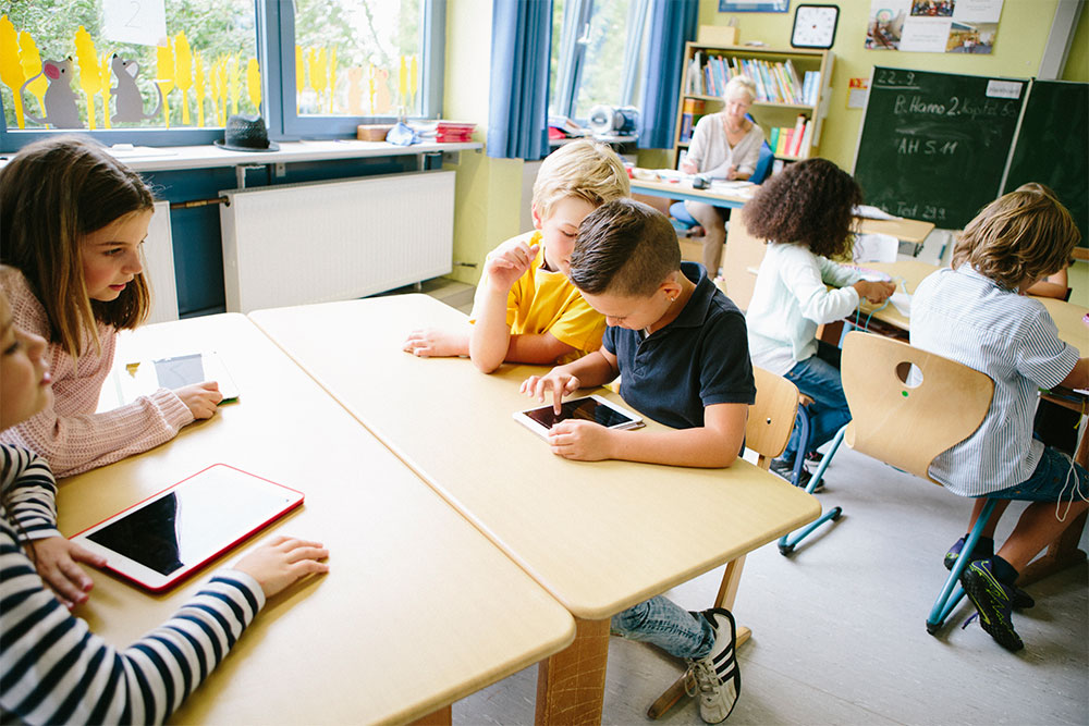 DigitalPakt Schüler in digitale Klasse mit Tablet und Notebook